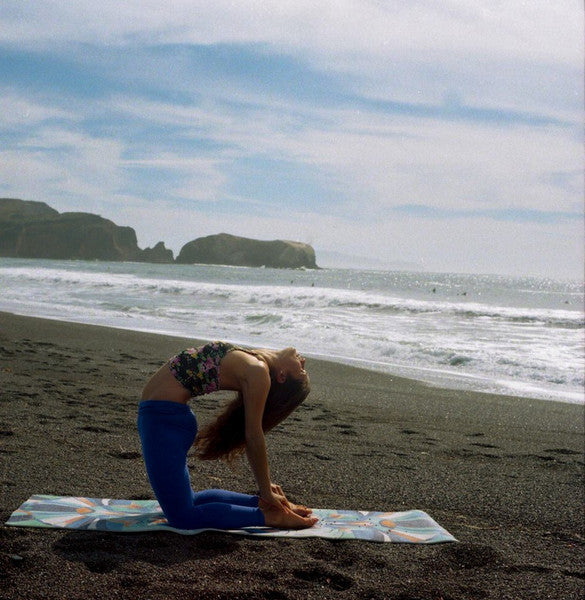 Person Doing Yoga On Mat By The Ocean
